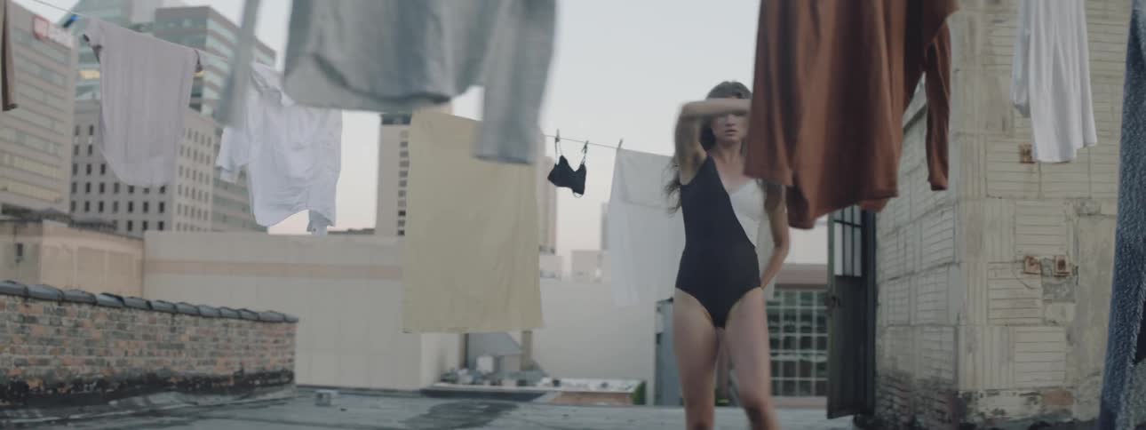 A young woman dances on a rooftop