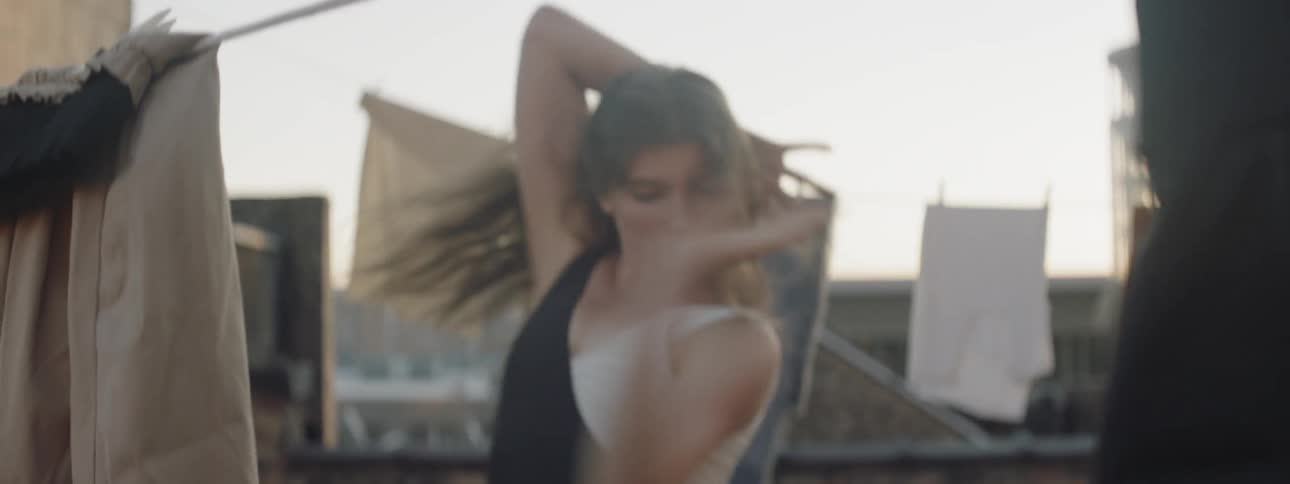 A young woman dances on a rooftop