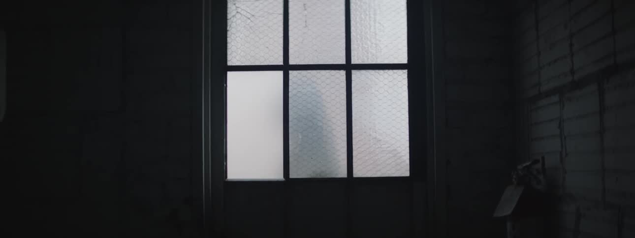 A person walks past a door with textured glass