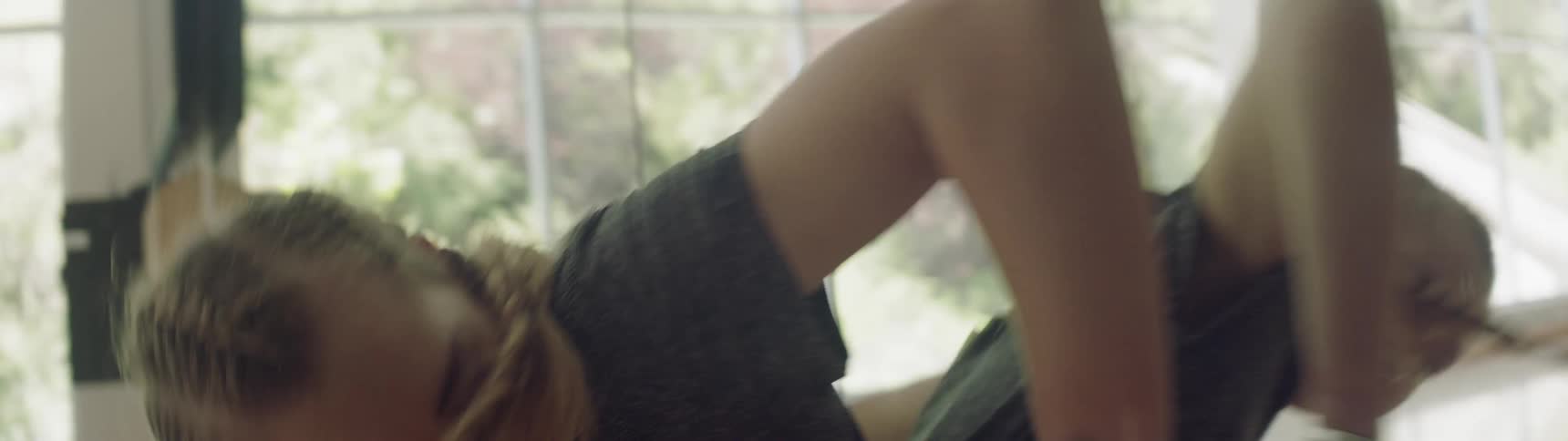 A woman is dancing leaning against a mirror