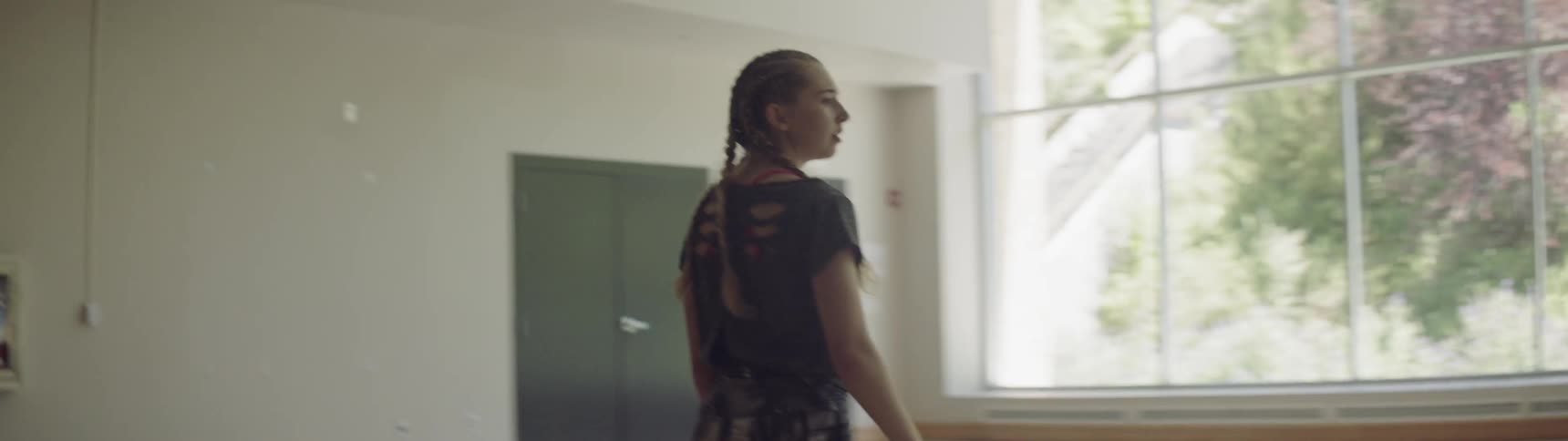 Frustrated girl flings down water bottle indoors during daylight