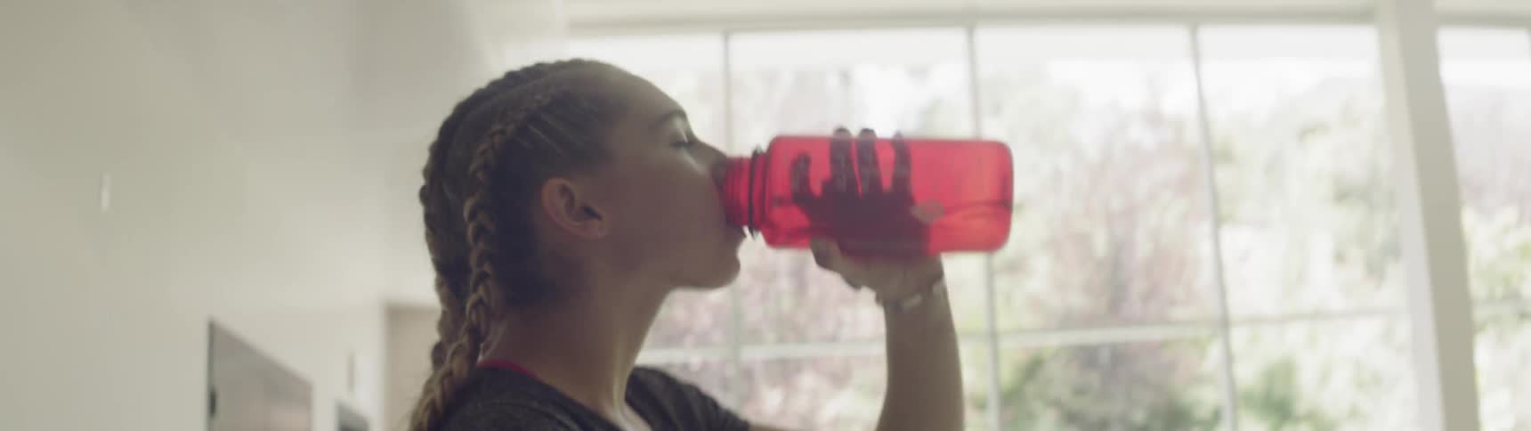 A woman is drinking out of a water bottle
