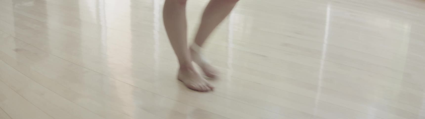 A ballet dancer walks across a stage