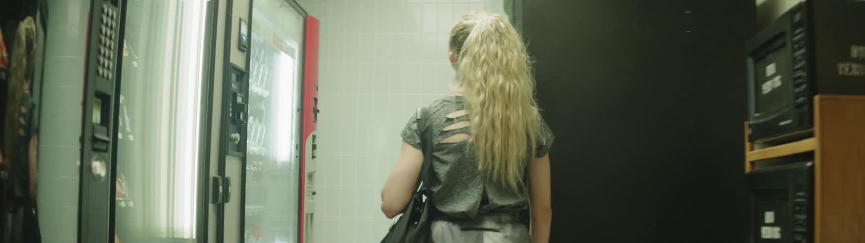 A woman is walking to vending machines