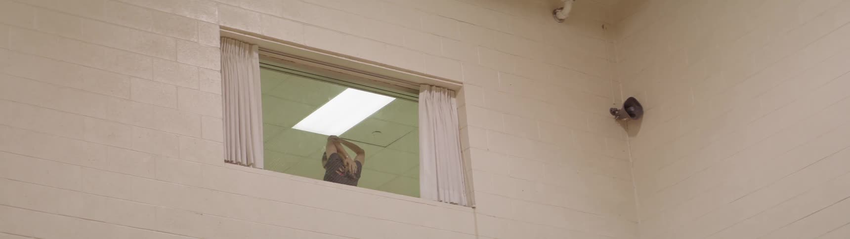 A woman standing in a window stretches