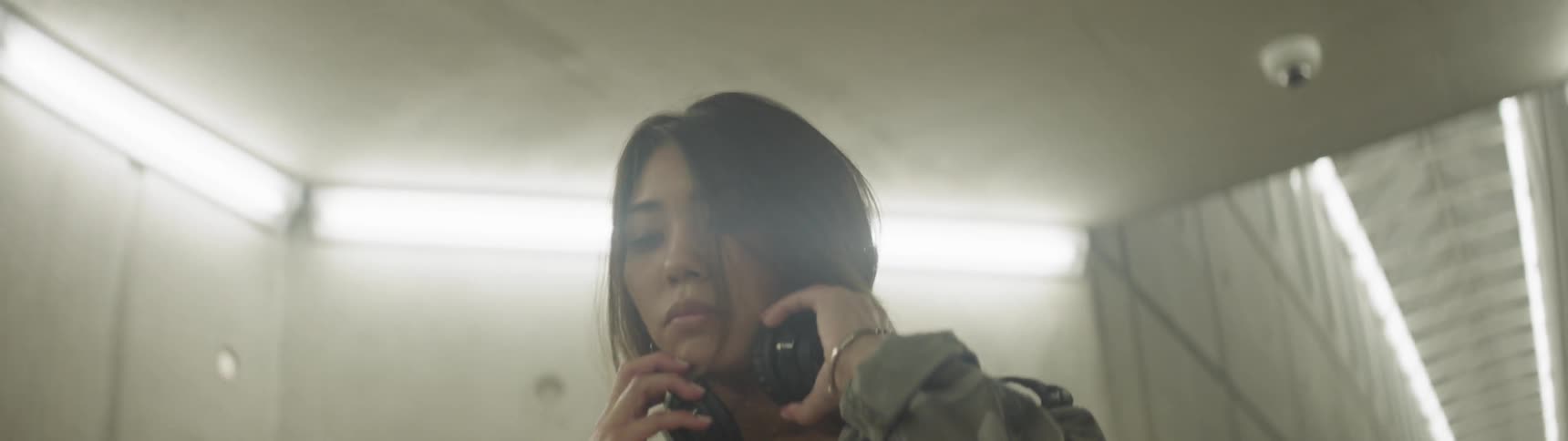 A woman puts down a bag and puts on headphones