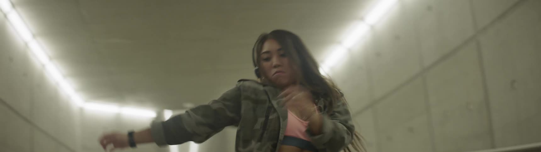 A woman dancing in a well lit tunnel