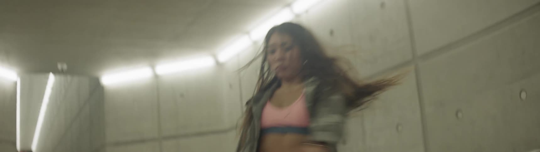 A young asian woman dances in a tunnel