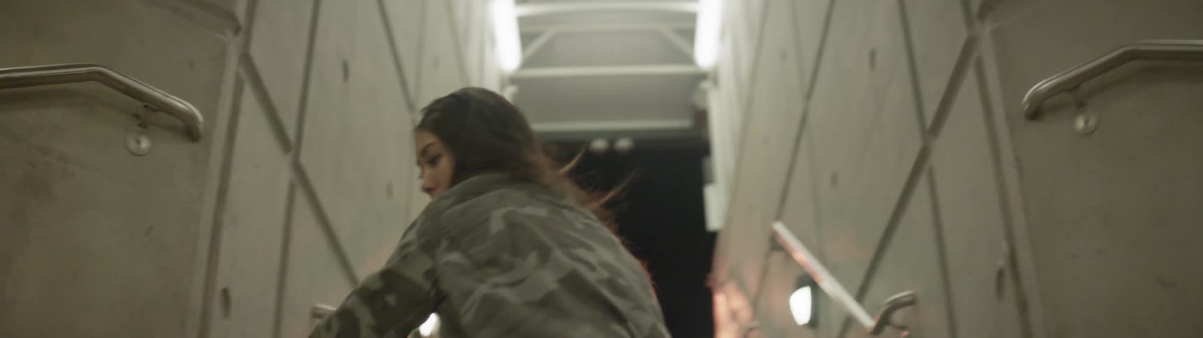 A woman dances around in a stairwell