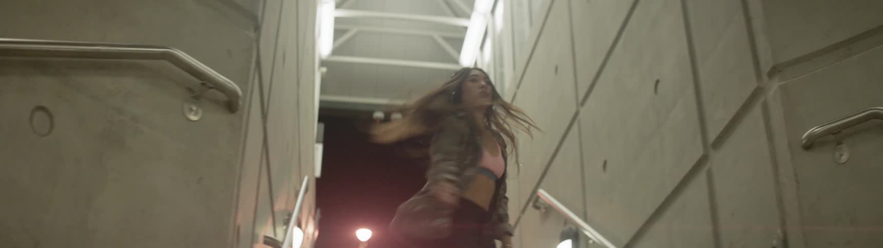 A woman dances enthusiastically on a stairway