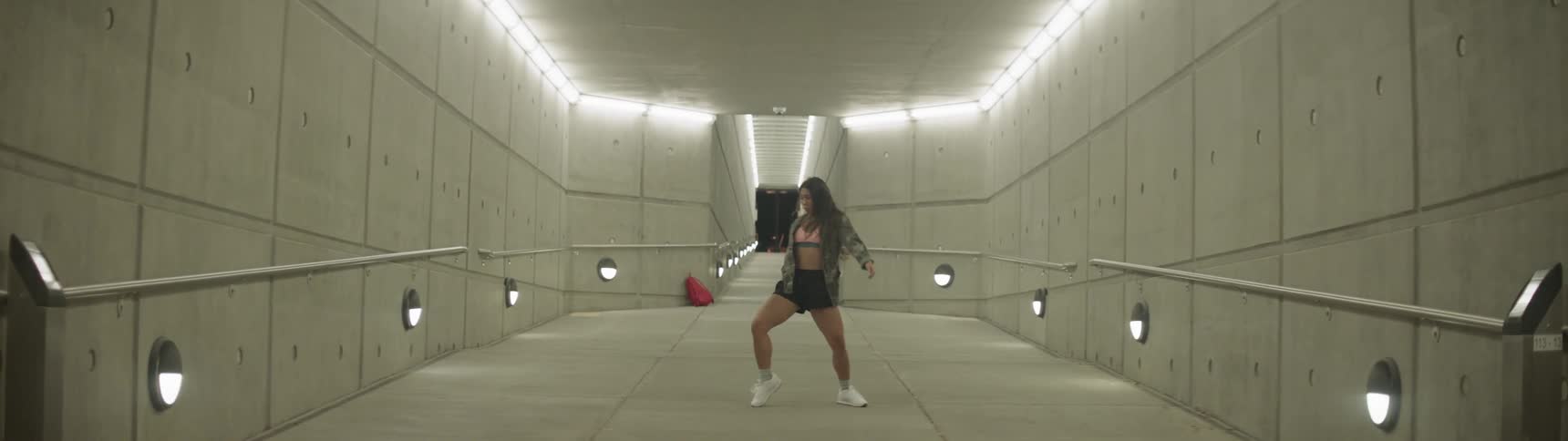 Woman dancing on the hallways of a subway station