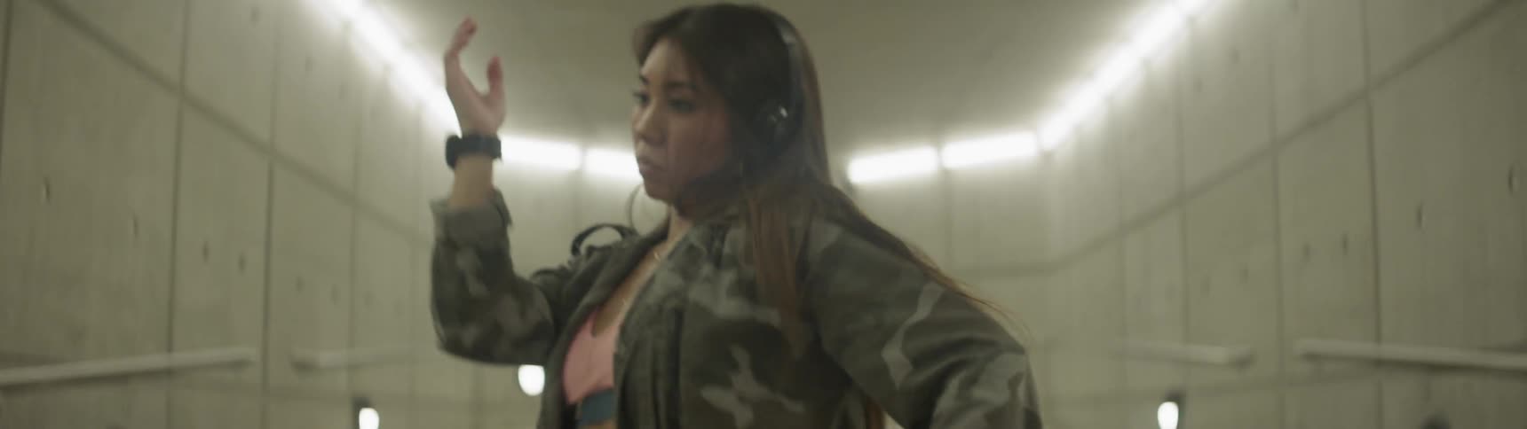 A woman dances in a hallway