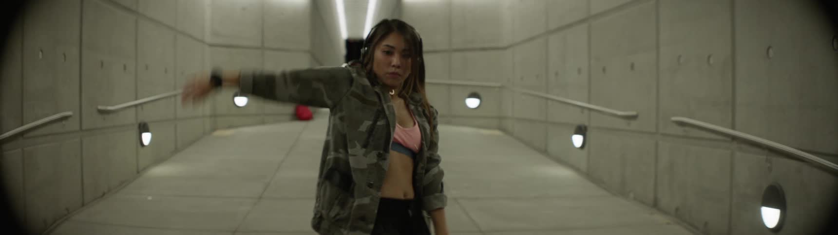 Woman dancing on the hallway of a subterranean station