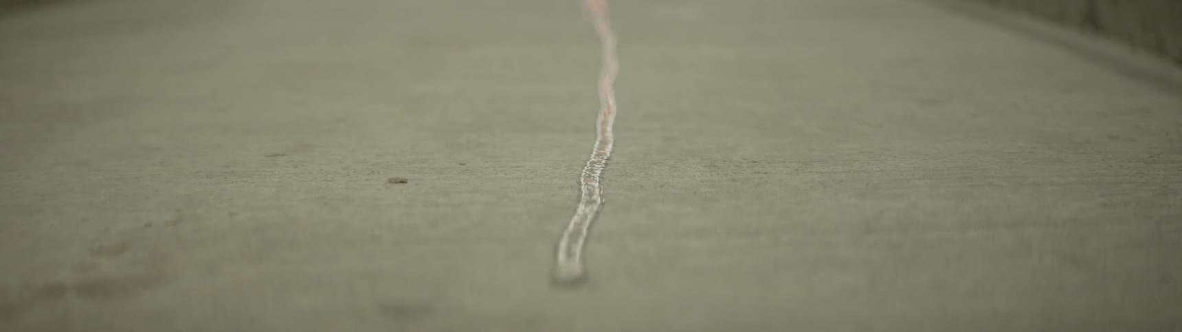 A drop of water flowing down a concrete path