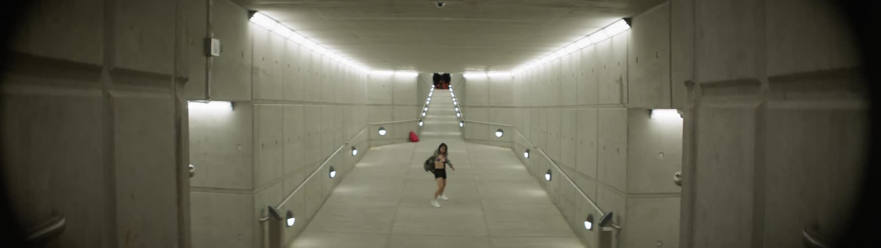 A woman dances in an empty pedestrian tunnel