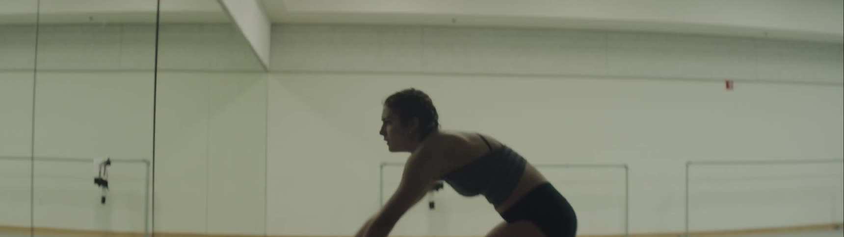 Young woman dances in front of mirror in dance studio