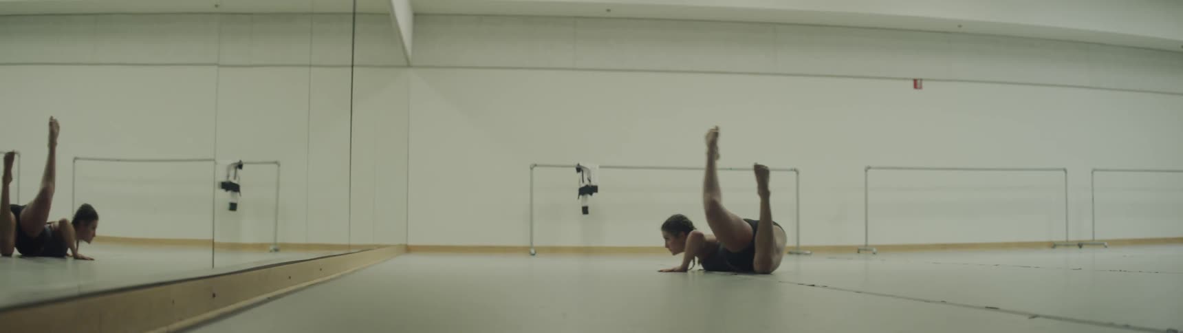 A woman is dancing in the dance hall doing splits