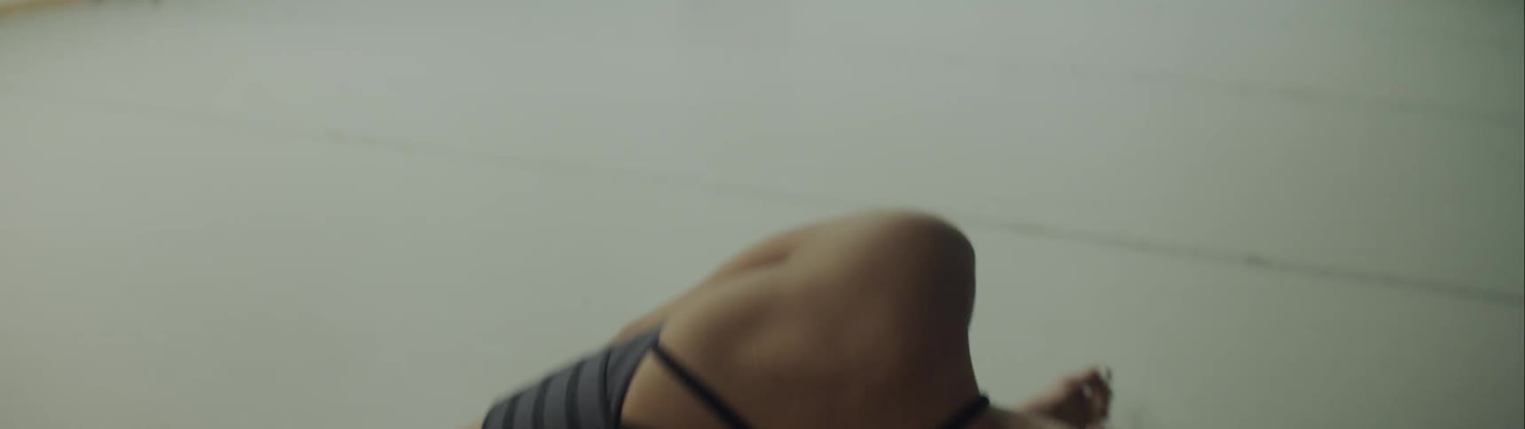 A woman is dancing on the floor of the studio