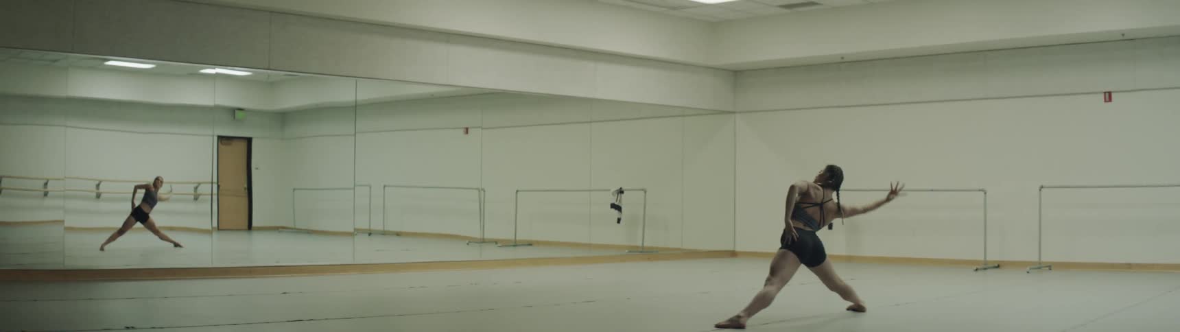 Girl dances in front of mirror in the big gym