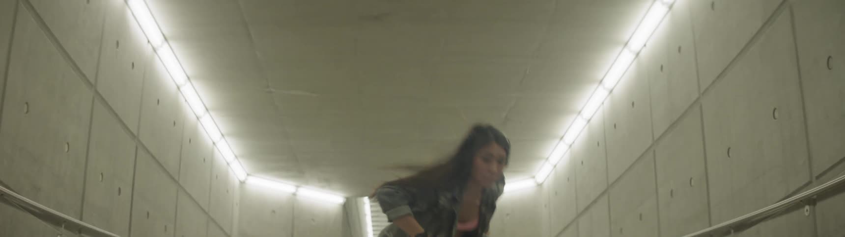 A woman dances in a corridor