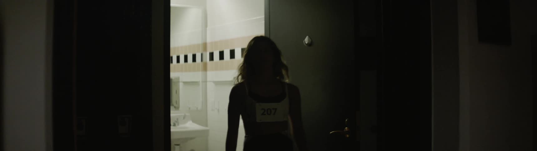 A female track athlete storms out of a bathroom