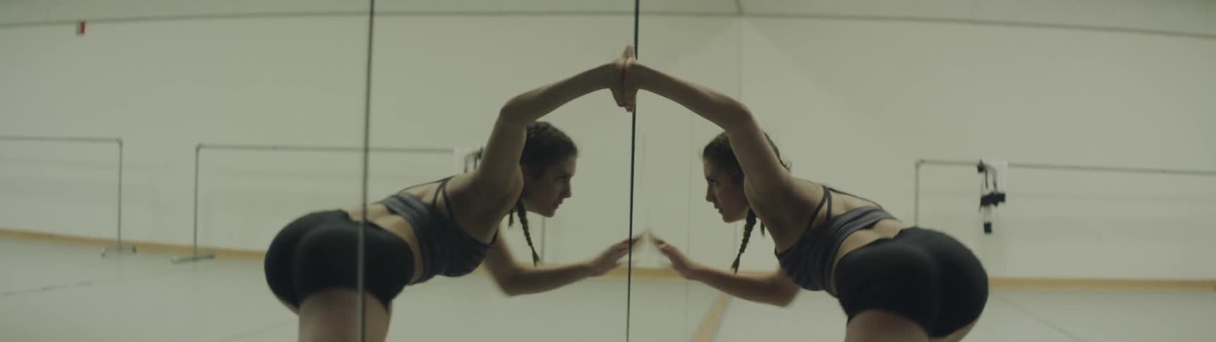 A woman dances up against a mirror