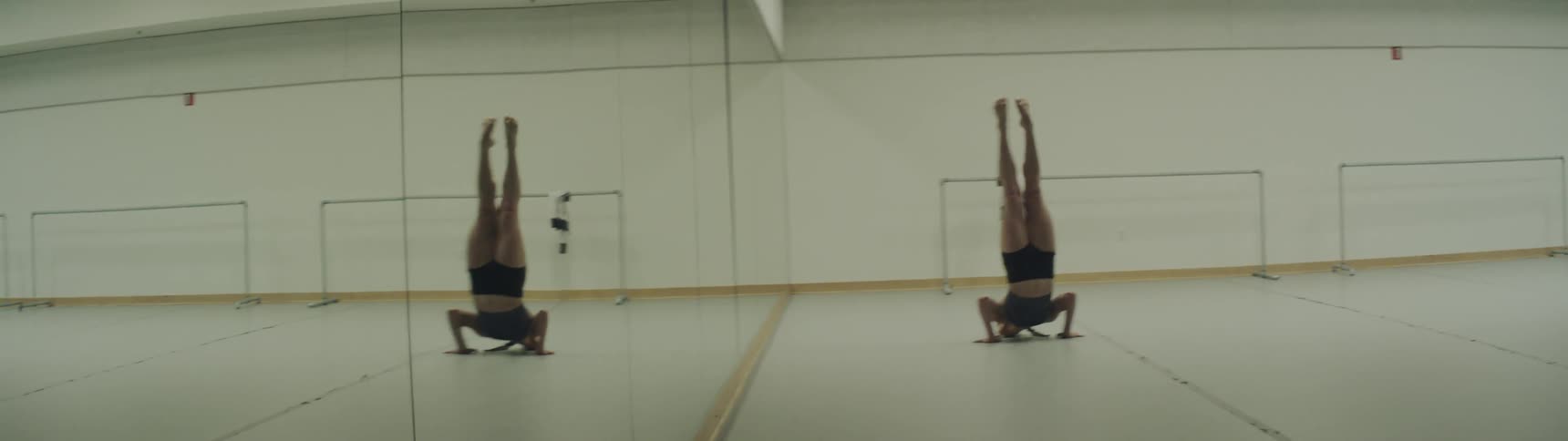 A white woman dances in front of a mirror at a dance studio