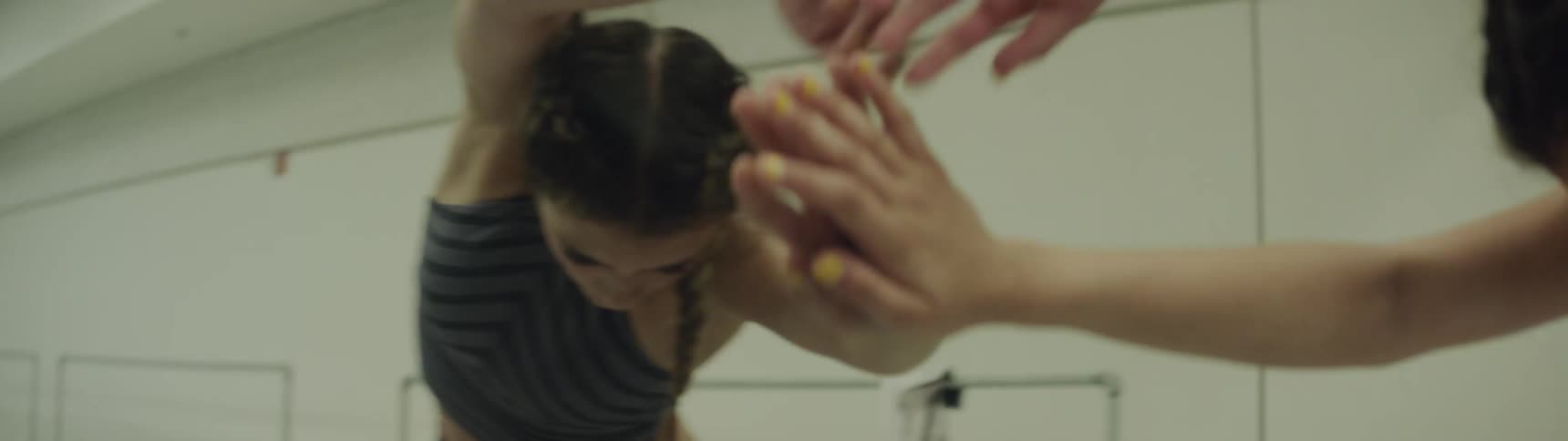 Girl with braided hair dances by touching the mirror in a room