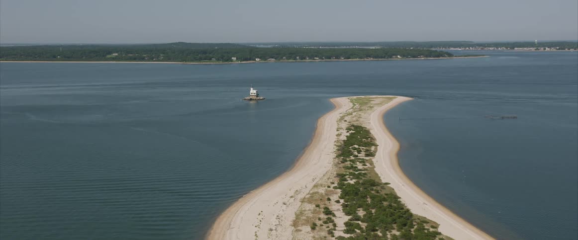 A peninsula surrounded by a large body of water near a lighthouse