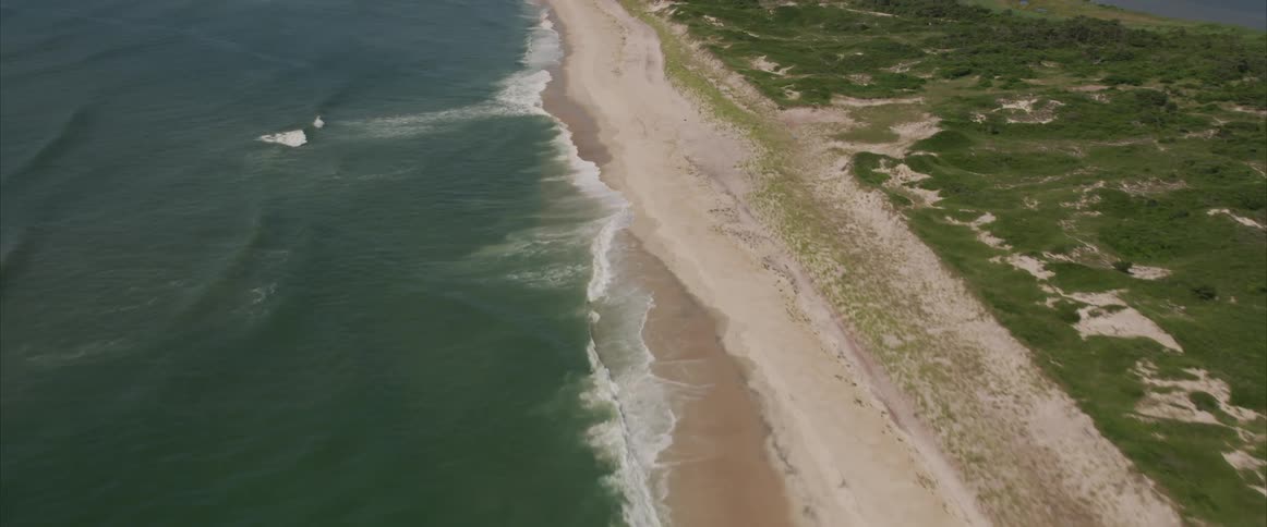 A body of water along a large shoreline near grass