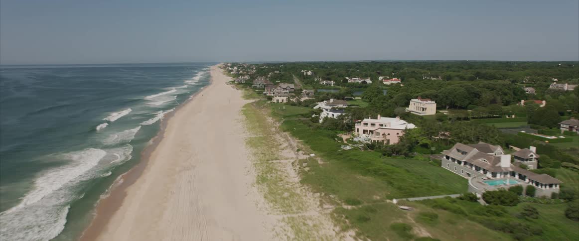 Ocean waves hit the shore throughout the coastline on a sunny