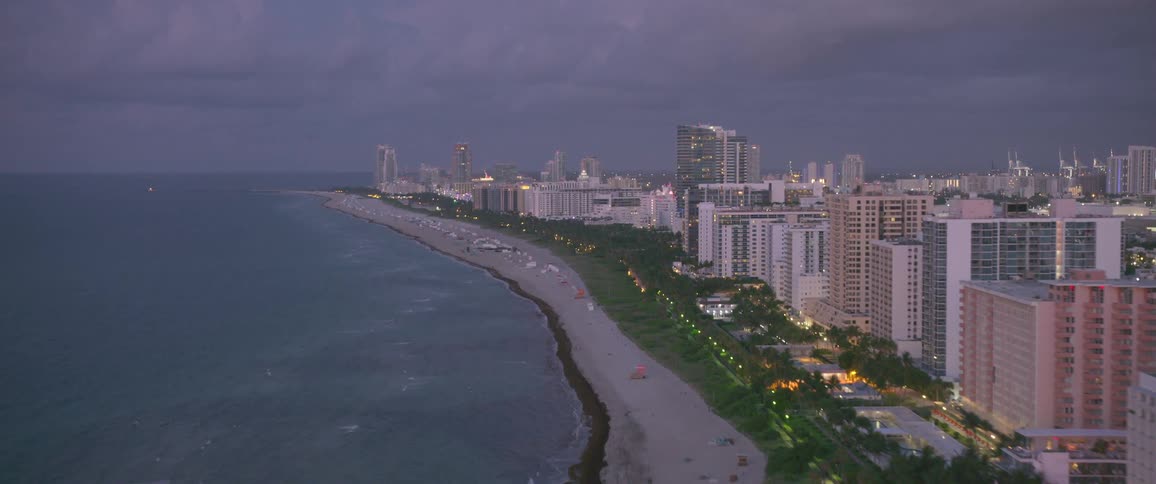 A city with a body of water and a beach in the front