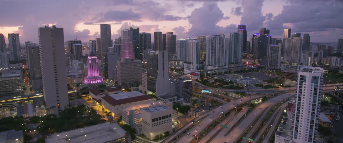 City traffic moves throughout a city at dawn