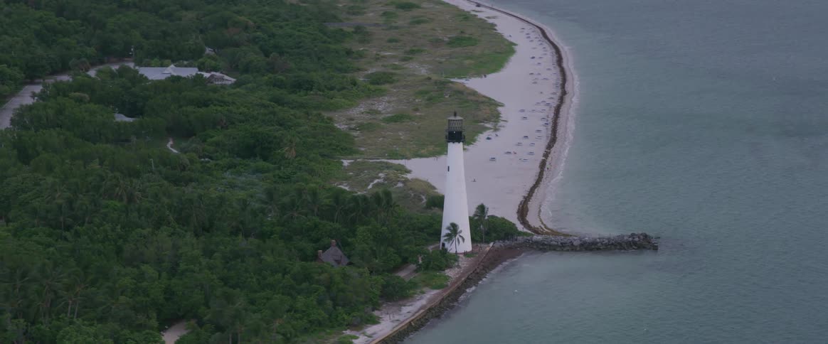 Lighthouse near on edge of forest beach and ocean