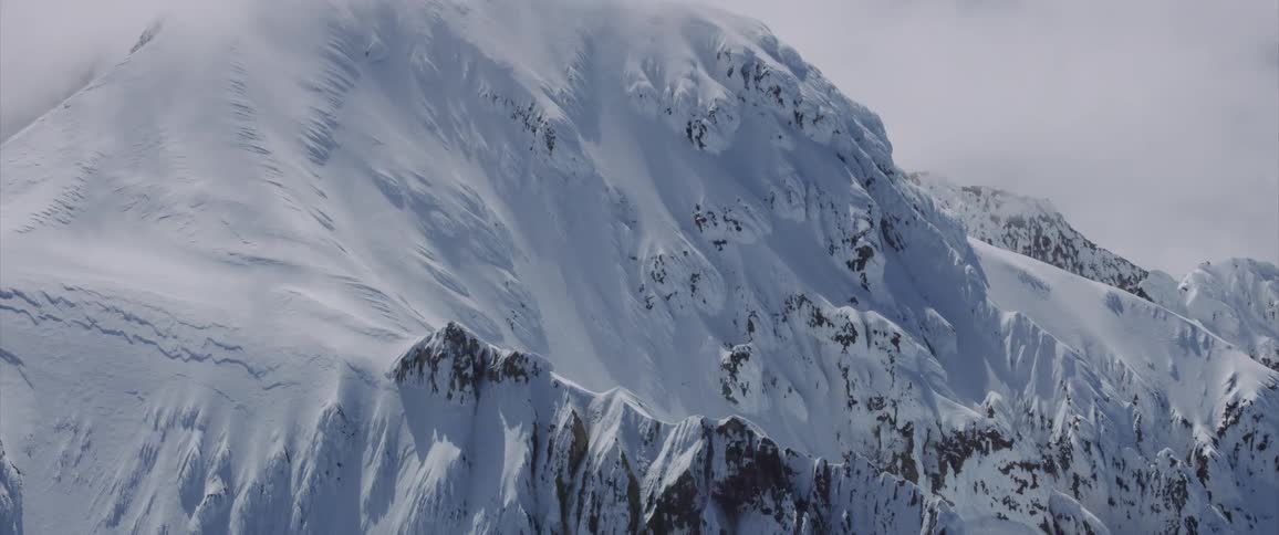 Skyline of the big snowy mountain whose peak is covered by clouds