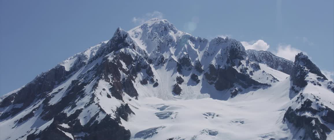 A snow capped mountain peak during the day