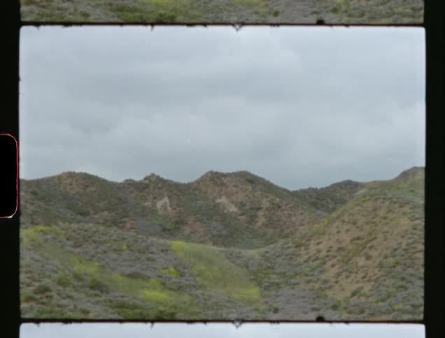 Rolling meadows are depicted on vintage film