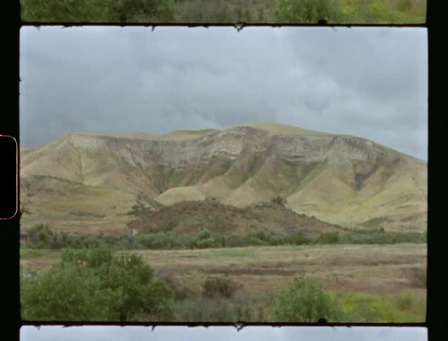 An old film with a green mountain on it