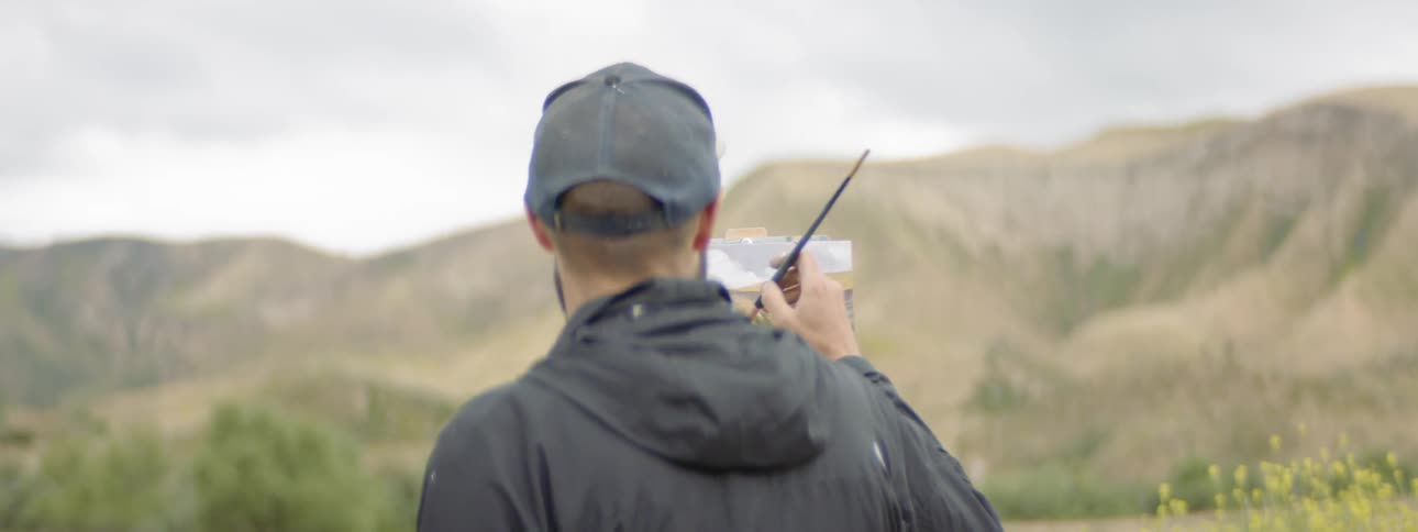 A man is painting outdoors