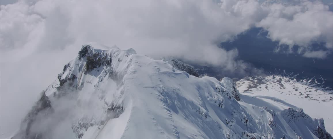Snow covers a mountain peak and surrounding valley