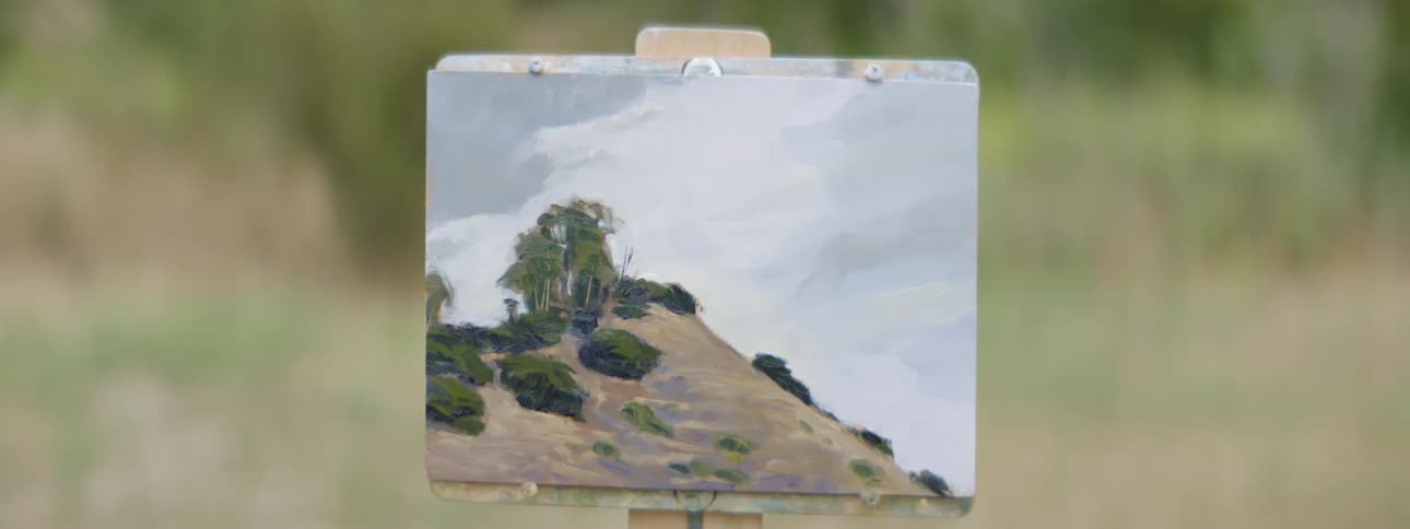A painting of a desert scene stands tall in the midday sun