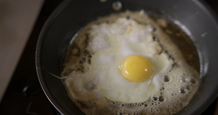 A close-up view of an egg being fried on a stove.