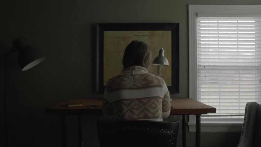 A young woman sits at her desk