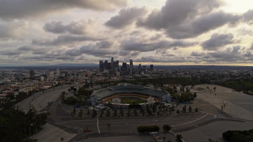 The camera looks out over a stadium and a city
