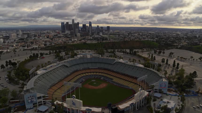 The los angeles dodgers baseball stadium with the la skyline on the horizon