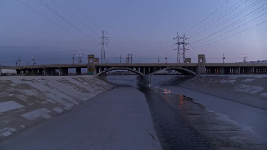 A concrete flood control channel in the evening
