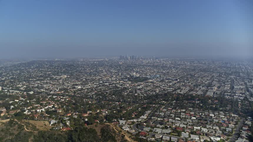 A sprawling city surrounds a compact downtown area on a sunny but hazy day