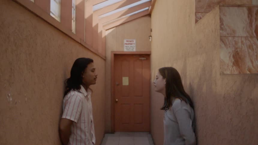 Man and woman face each other in hall and talk