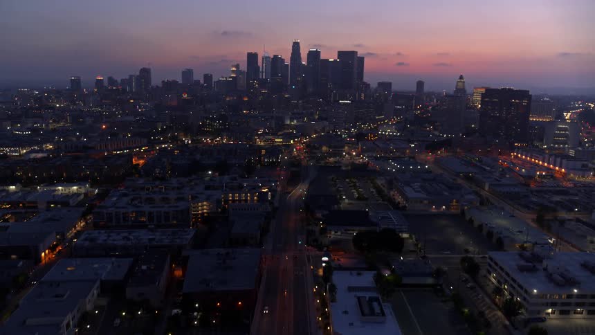 Cars travel along highway away from downtown at sunset