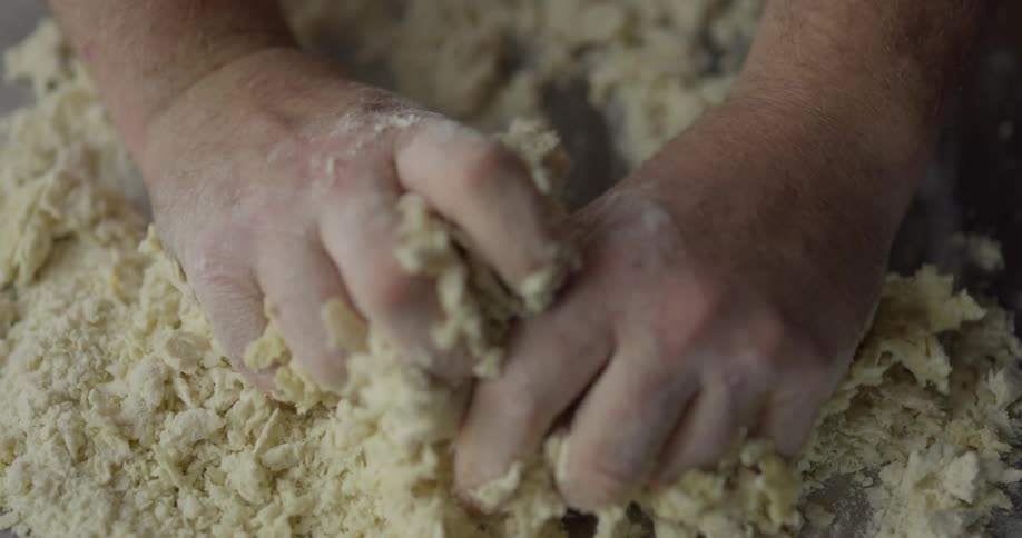 A person mixes dough with their hands